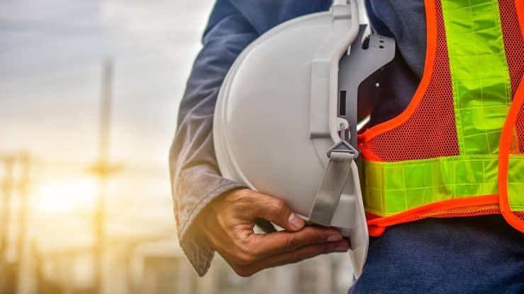 Profesional de seguridad e higiene con casco y chaleco reflectante en planta